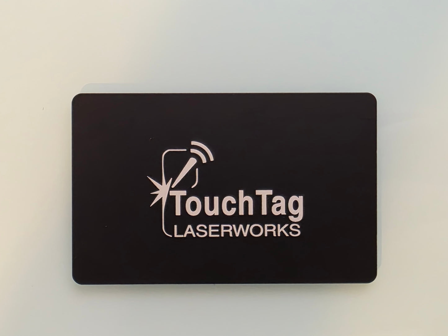 Black card with 'TouchTag Laserworks' logo on a light gray background